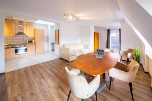 een keuken en een woonkamer met een houten tafel en stoelen bij ArtHotel City in Neurenberg