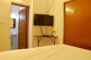 1 dormitorio con 1 cama y TV en la pared en Vacation villa en Yercaud