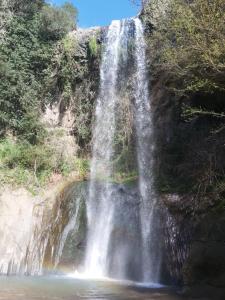 a waterfall on the side of a rocky cliff at La casa nel borgo in Bracciano