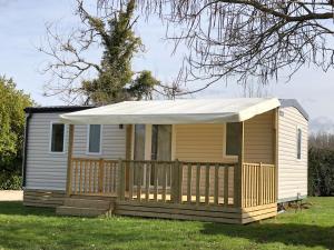 a small yellow house with a white awning at Camping Moulin de Collonge in Saint-Boil