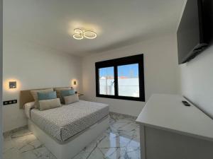 biały pokój z łóżkiem i oknem w obiekcie Luxury bungalow Holycan w mieście San Bartolomé