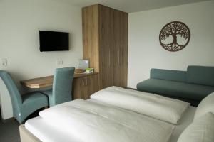 um quarto com uma cama, uma secretária e uma cadeira em Pension Strobl em Mondsee