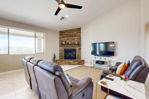 a living room with leather chairs and a fireplace at Desert Jewel in Scottsdale