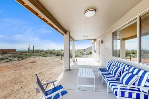 a porch with blue and white chairs and a view of the desert at Desert Jewel in Scottsdale
