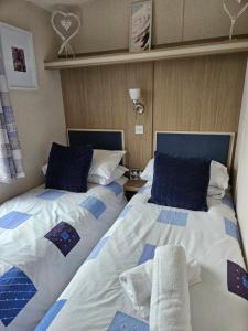 Ocean Pearl , 20 Circular , Challaborough Bay في Bigbury: سريرين يجلسون بجانب بعض في غرفة