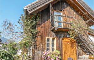 a wooden house with a door and flowers at Nice Home In Mhldorf With 2 Bedrooms And Sauna in Mühldorf