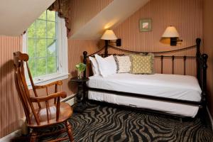 a bedroom with a bed and a chair and a window at The Equinox Golf Resort & Spa in Manchester