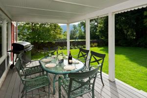 a table and chairs on a porch with a grill at The Equinox Golf Resort & Spa in Manchester