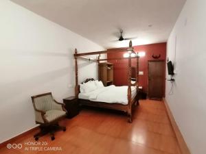 um quarto com uma cama e uma cadeira em Vacation villa em Yercaud