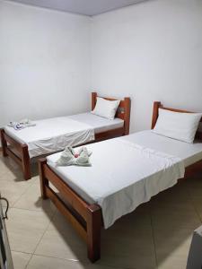 two beds with shoes sitting on them in a room at Hotel Zarina in Villavicencio