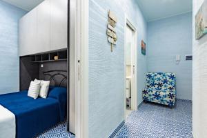 Cette chambre bleue comprend un lit et une chaise. dans l'établissement Appartamento Stella Marina 3 - MyHo Casa, à San Benedetto del Tronto