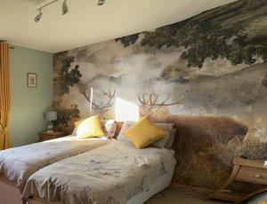 two beds in a room with a painting on the wall at Princes point villa all on ground floor in Portree