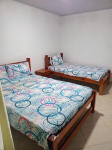 two beds sitting next to each other in a room at Hotel Zarina in Villavicencio