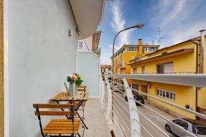 - un balcon avec une table et des chaises dans un bâtiment dans l'établissement Appartamento Stella Marina 3 - MyHo Casa, à San Benedetto del Tronto