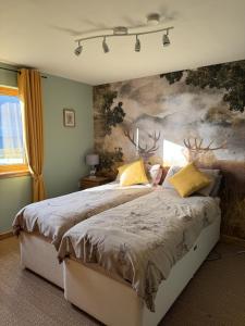 a bedroom with a bed with a painting on the wall at Princes point villa all on ground floor in Portree