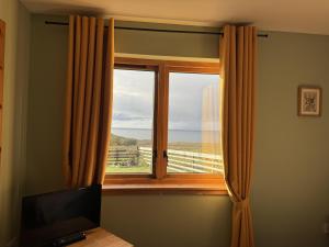 a window with a view of the ocean at Princes point villa all on ground floor in Portree