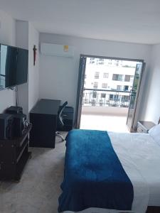 Schlafzimmer mit einem Bett, einem Schreibtisch und einem Fenster in der Unterkunft Hermoso in Neiva
