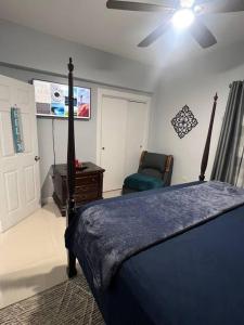 a bedroom with a bed and a chair and a ceiling fan at Sunrise Manor 2-Bedroom APT#2 in Cherryfield