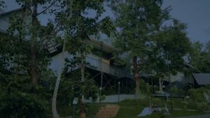 un bâtiment avec des arbres devant lui dans l'établissement Mountain Vibes Resort Wayanad, à Wayanad