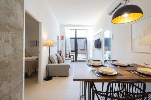 comedor y sala de estar con mesa y sillas en FLORIT FLATS - The Pitiusas Rooms, en Valencia