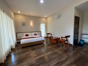 - une chambre avec un lit, une table et des chaises dans l'établissement Mountain Vibes Resort Wayanad, à Wayanad