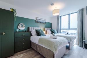 two beds in a bedroom with a green wall at NEW! Pristine 2-Bed Flat on Liverpool by 53 Degrees Property, Amazing Location, Sleeps 6! in Liverpool