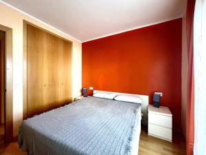 1 dormitorio con cama y pared roja en AQUAMARINA011, en Roses