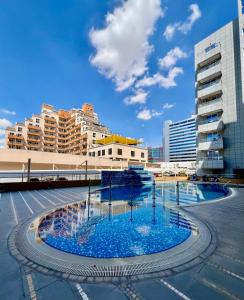 uma grande piscina no meio de uma cidade em Silicon Path Spacious studio no Dubai