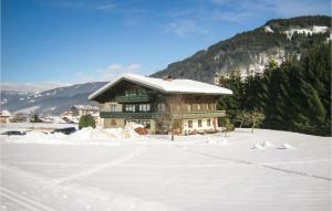 un grande edificio nella neve con alberi e montagne di Awesome Apartment In Flachau With 2 Bedrooms And Internet a Flachau