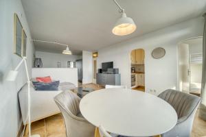 - un salon avec une table et des chaises blanches dans l'établissement Ferienpark - Haus E, App 0E0903, à Heiligenhafen
