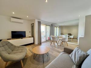 a living room with a couch and a table at Beau 2 pièces proche mer - piscine et clim in Vallauris