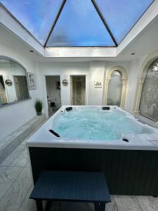 a large soaking tub in a room with a skylight at Historic Charm: *Perfect For Group Getaways* in Trowbridge