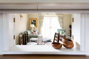uma vista para uma sala de estar com uma mesa e cadeiras em Cosy Cottage in Beautiful South Downs Walk 2 Pub em Chichester