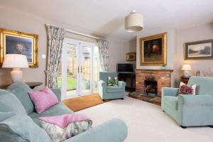uma sala de estar com mobiliário azul e uma lareira em Cosy Cottage in Beautiful South Downs Walk 2 Pub em Chichester
