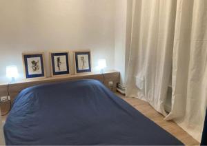 a bedroom with a bed with three pictures on the wall at Logement cosy en hyper-centre in Limoges