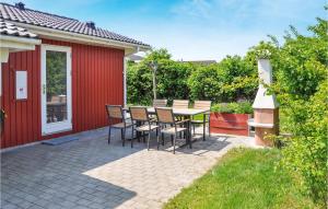 a patio with a table and chairs next to a red building at Holiday Home Fiskervej Sydals Xii in Skovby