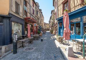 een straat met tafels en stoelen en parasols in een straat bij Joli studio en cœur de ville in Limoges