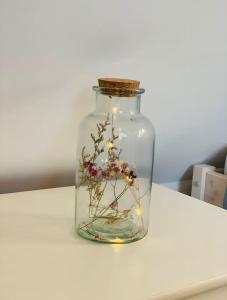 a glass jar with flowers in it on a table at Ferienhaus Allgäu Flughafen Memmingen in Benningen