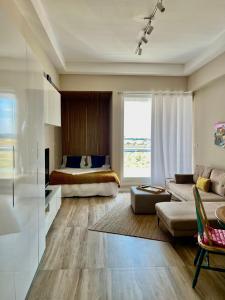 Silicon Path Spacious studio في دبي: غرفة معيشة مع سرير وأريكة