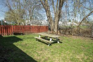 a wooden picnic table in the grass next to a fence at Homey Single Family on Old Orchard in Cornwall