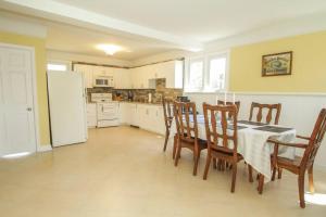 eine Küche mit einem Tisch und Stühlen sowie einem Kühlschrank in der Unterkunft Homey Single Family on Old Orchard in Cornwall