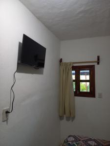 a room with a tv on a wall with a window at Hotel Paraíso de San Sebastián Jalisco in San Sebastián del Oeste