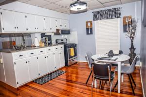 a kitchen with white cabinets and a table with chairs at Cozy 2BR Apartment, Balcony with City Skyline View, Mardi Gras Park, Free Parking, Wi-Fi in Mobile