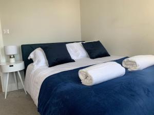 a large bed with two pillows on top of it at Two bedroom, modern spacious apartment. in Brentwood