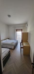 - une chambre avec deux lits, une chaise et une fenêtre dans l'établissement Da Carlino, à Peschici