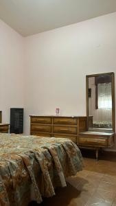 een slaapkamer met een bed, een dressoir en een spiegel bij La Querencia in Mercedes