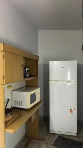 La cuisine est équipée d'un réfrigérateur blanc et d'un four micro-ondes. dans l'établissement La Querencia, à Mercedes