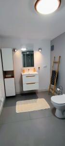ein weißes Bad mit einem Waschbecken und einem WC in der Unterkunft Apartament Sadyba in Świeradów-Zdrój