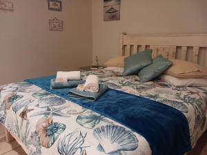 Una cama con un edredón azul y blanco. en Eagle's Rest, en Hartenbos