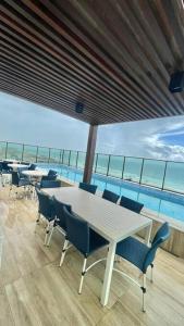 uma sala de jantar com mesa e cadeiras e uma piscina em Studio Encantador a Beira Mar e Próximo do Centro de Convenções em Salvador